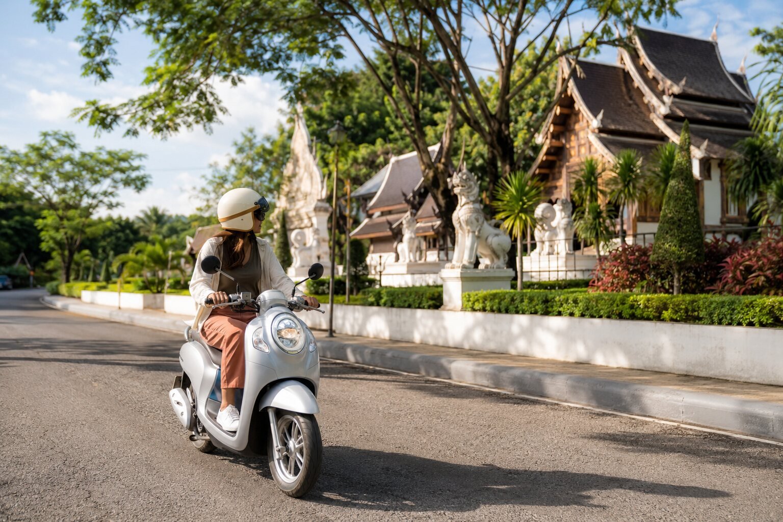 Traveller riding a light scooter near Lanna-style architecture in Chiang Rai
